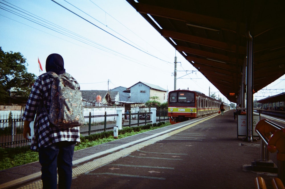 a man is waiting for a train at a train station