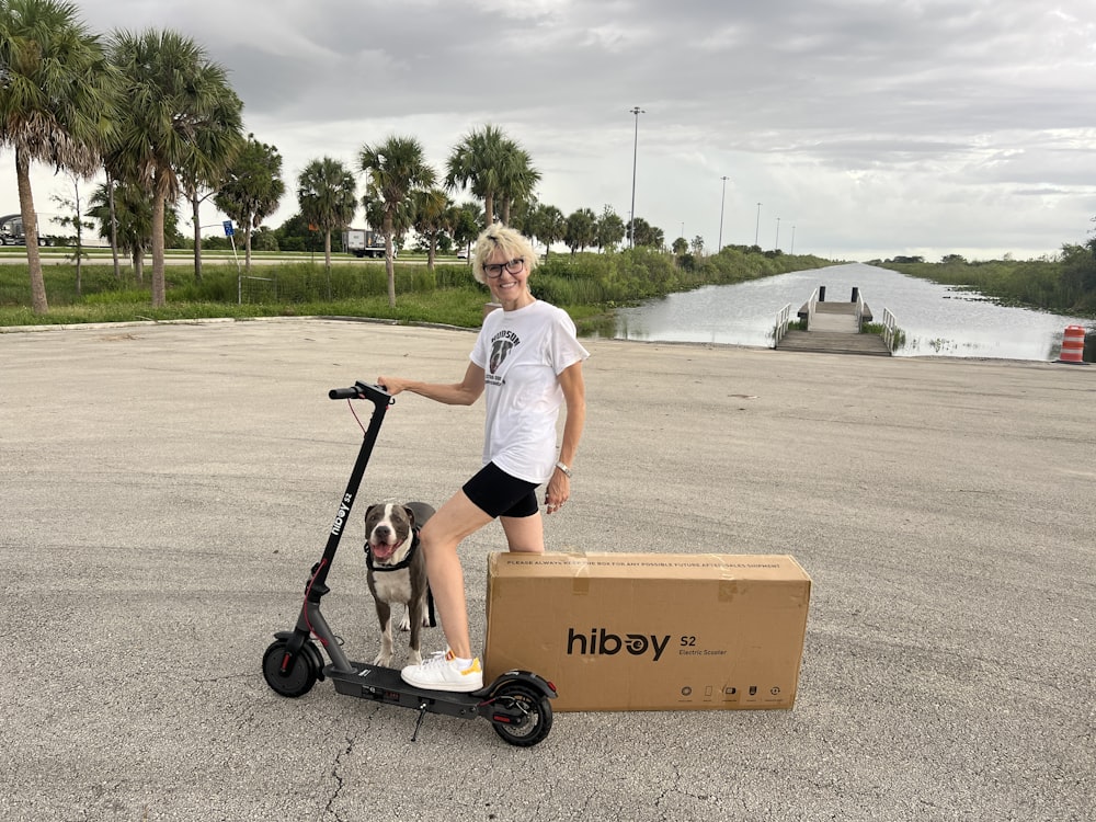 a man standing next to a dog on a scooter