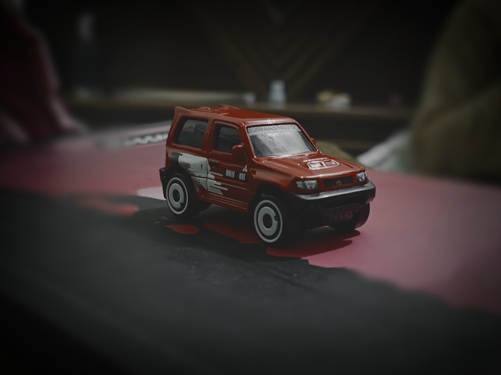 a red toy truck is on a table