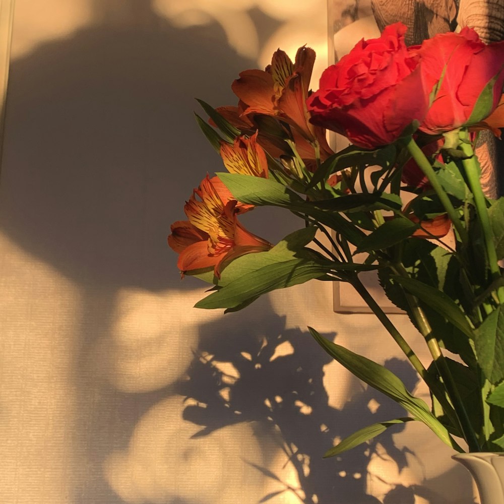 a vase filled with red flowers on top of a table