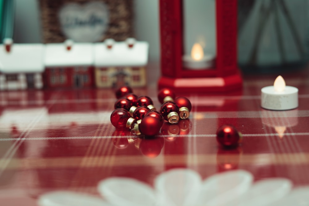 a red table topped with red ornaments and a candle
