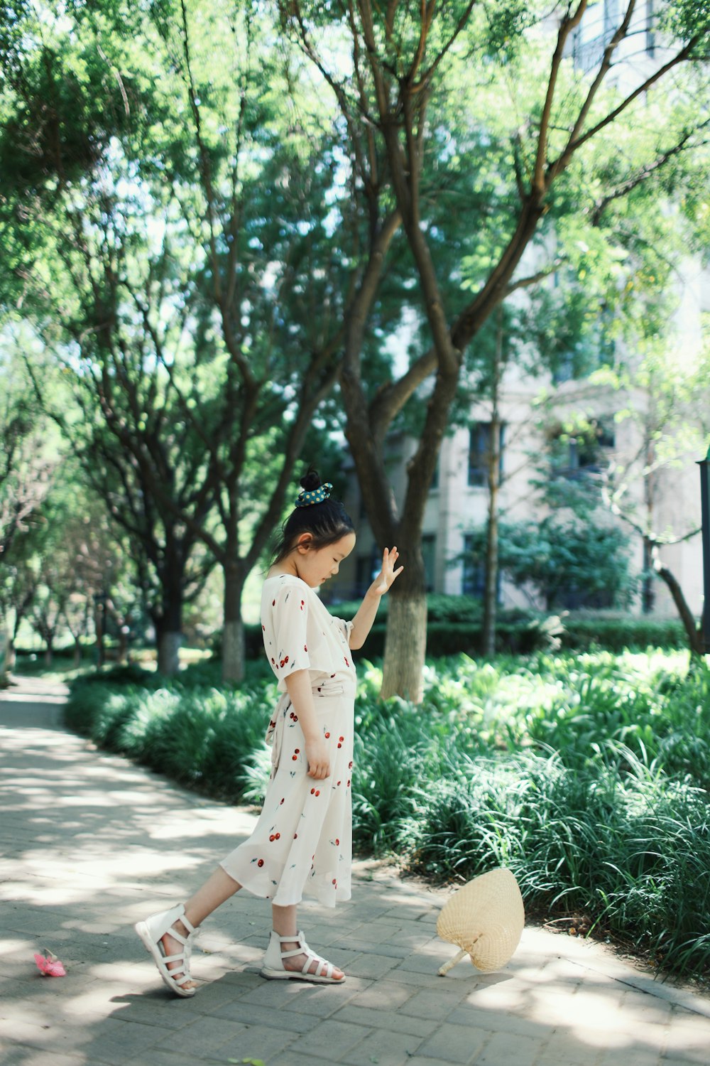 a woman in a white dress walking down a sidewalk