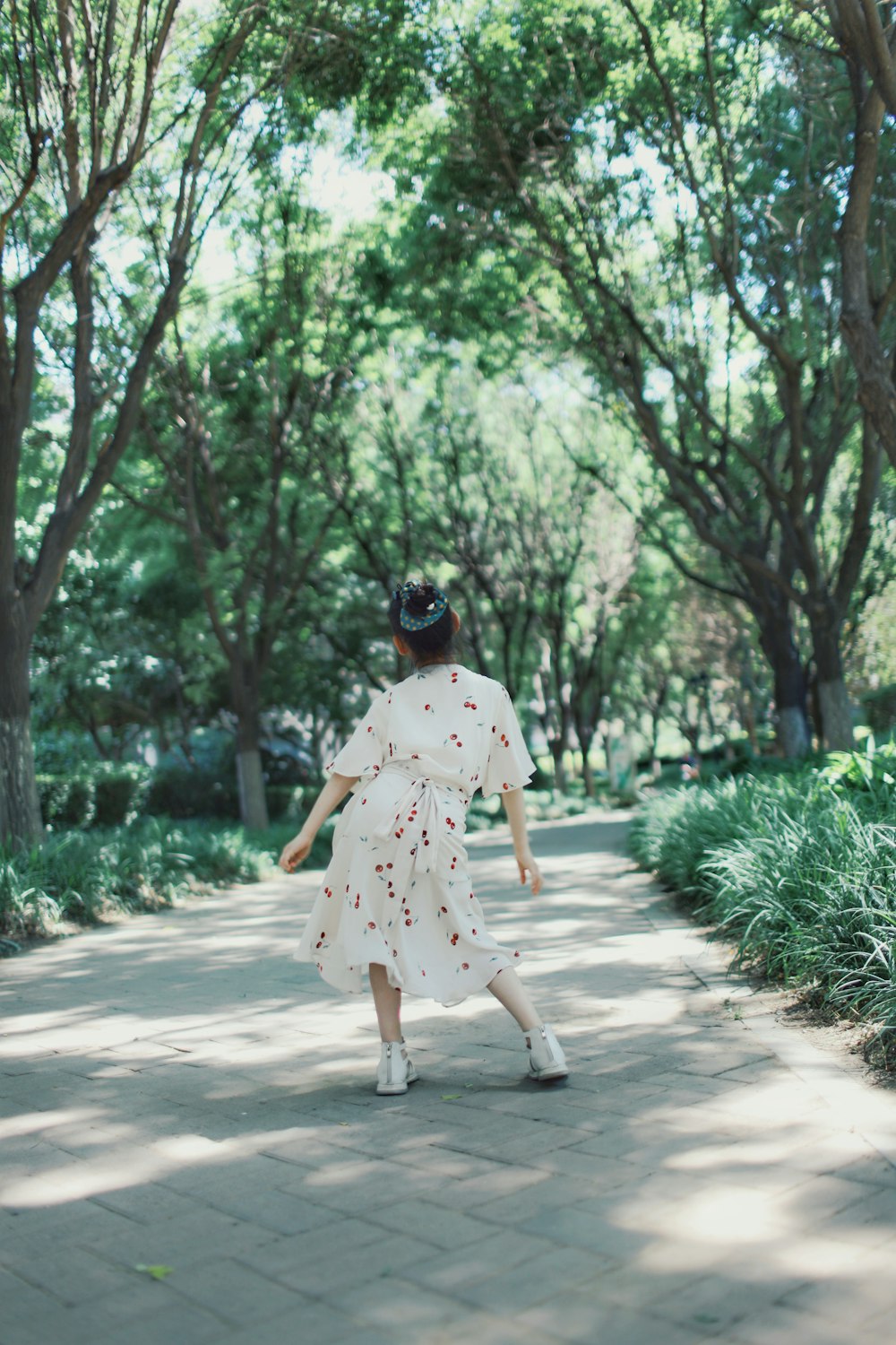 a woman in a white dress walking down a sidewalk