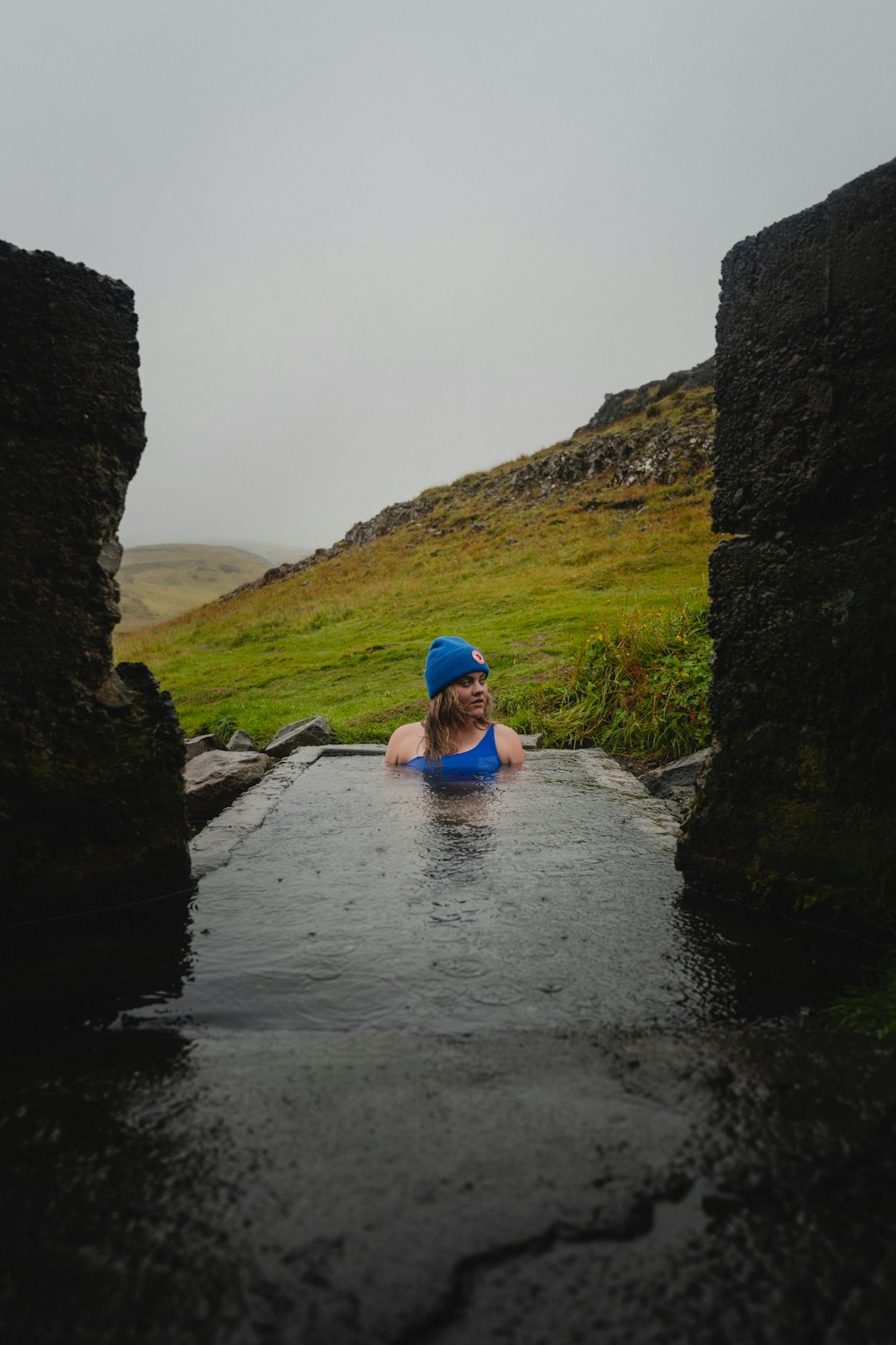 a woman in a pool of water with a hat on