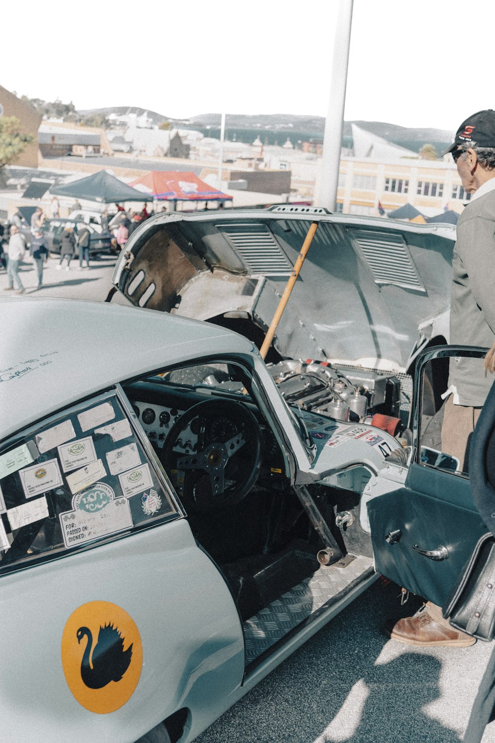 a man standing next to a broken down car