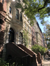 Exterior view of the classic brownstone facade bathed in afternoon light.