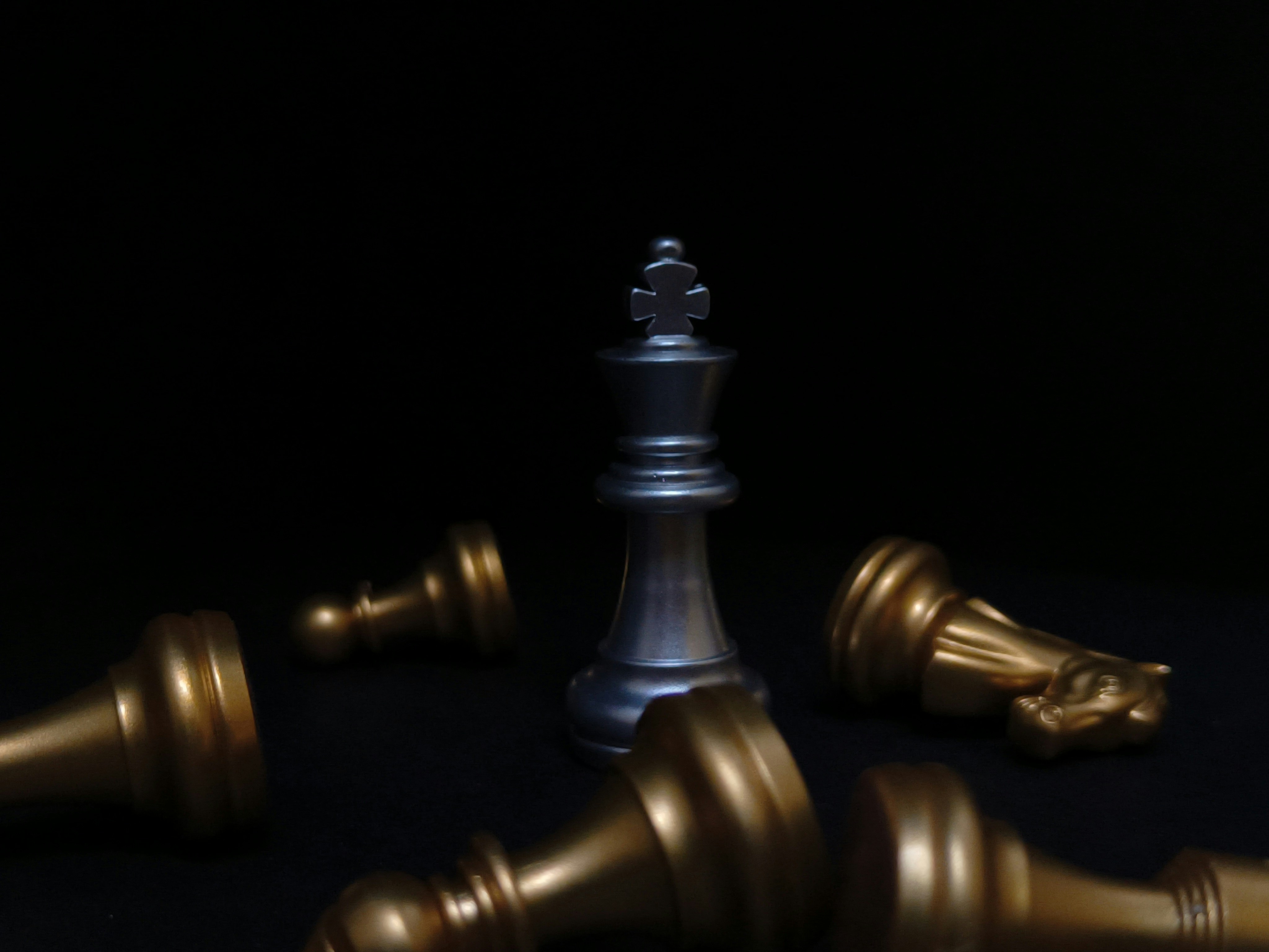 a silver and gold chess set on a black background