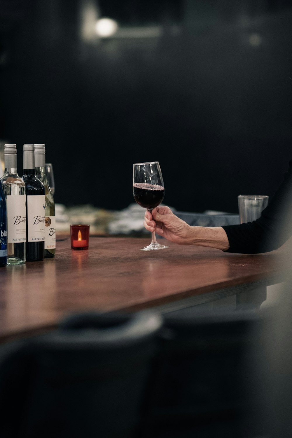 a person sitting at a table with a glass of wine
