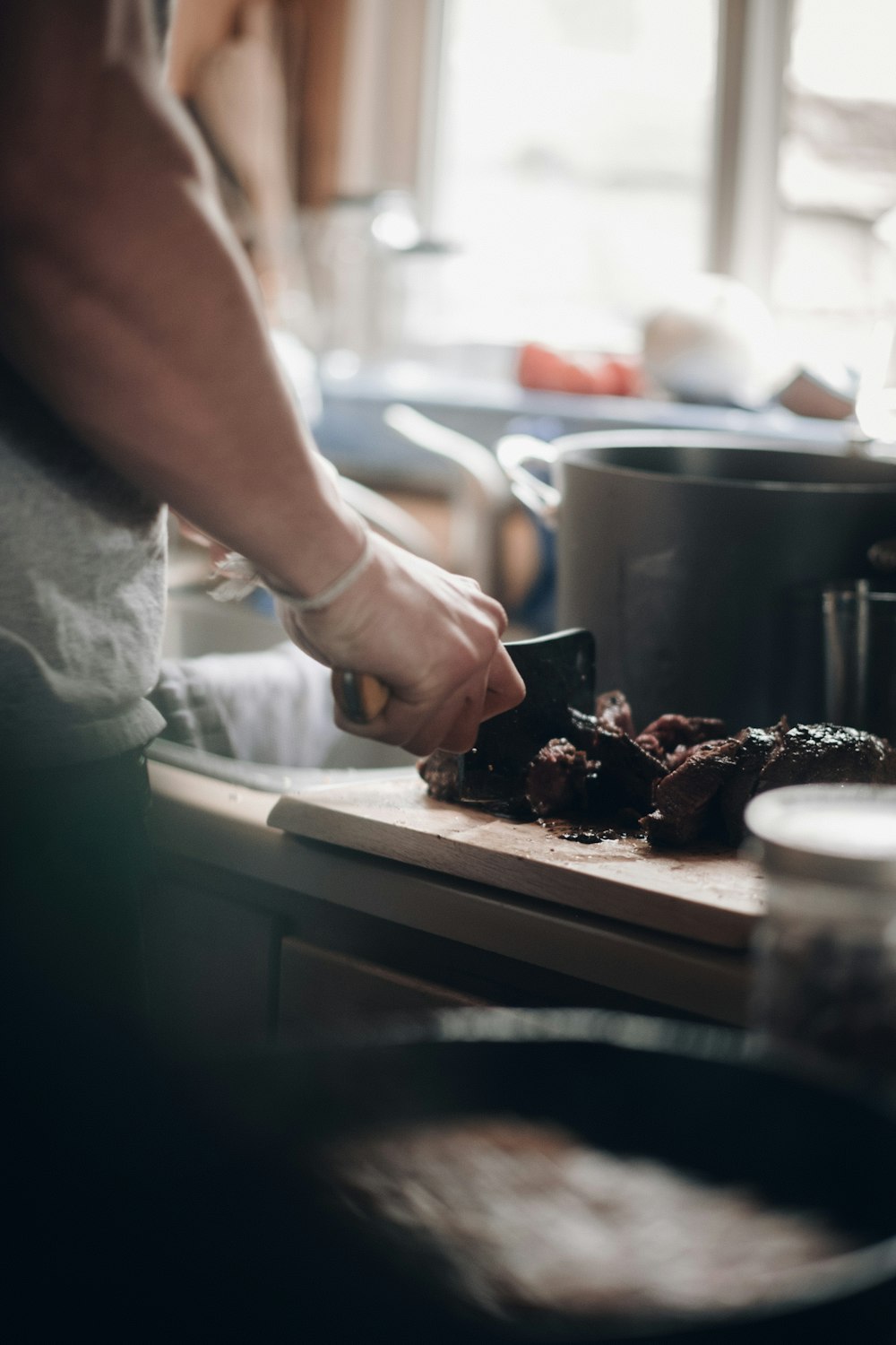 a person cutting up food on a cutting board