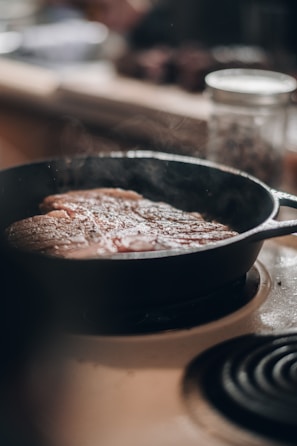 A cozy kitchen scene with a cast iron skillet sizzling on the stove.