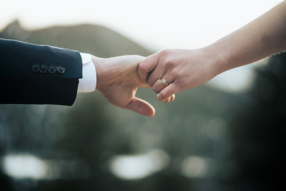 a close up of two people holding hands