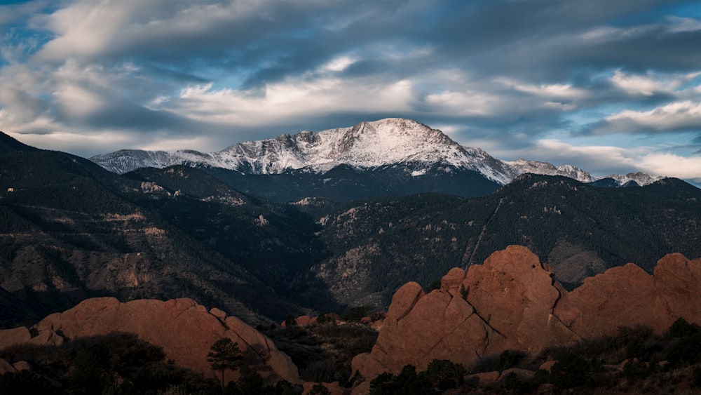 a mountain range with snow capped mountains in the background