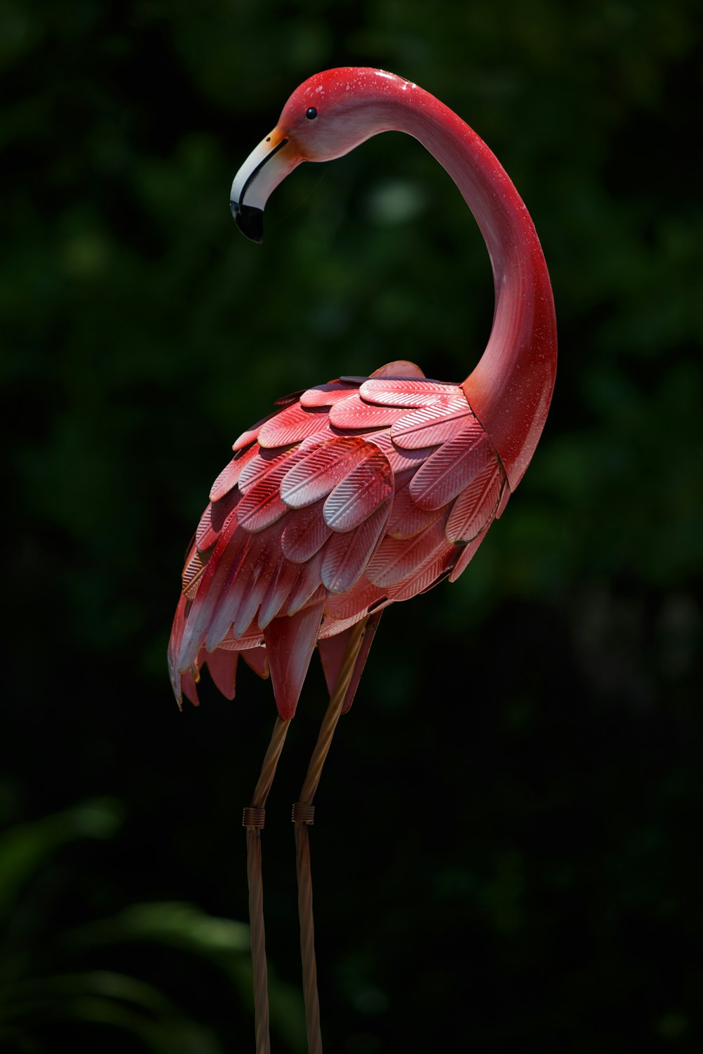 Un flamenco rosado parado frente a un bosque