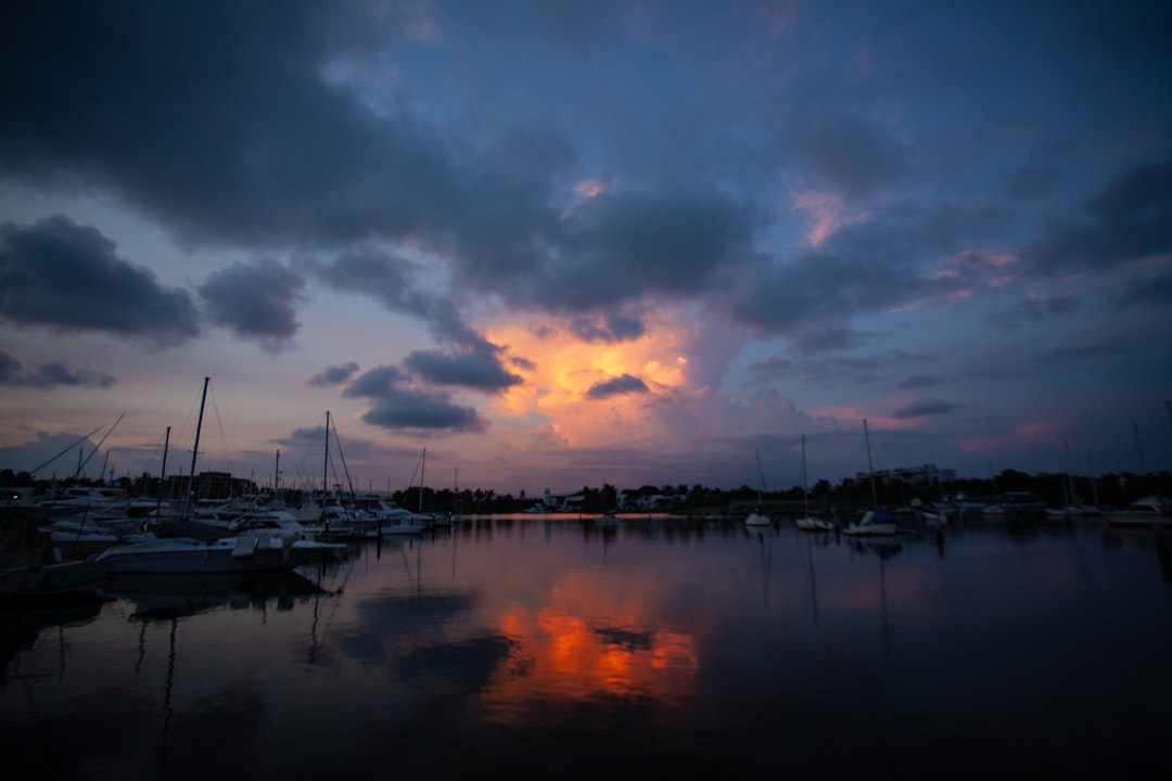 a harbor filled with lots of boats under a cloudy sky,
