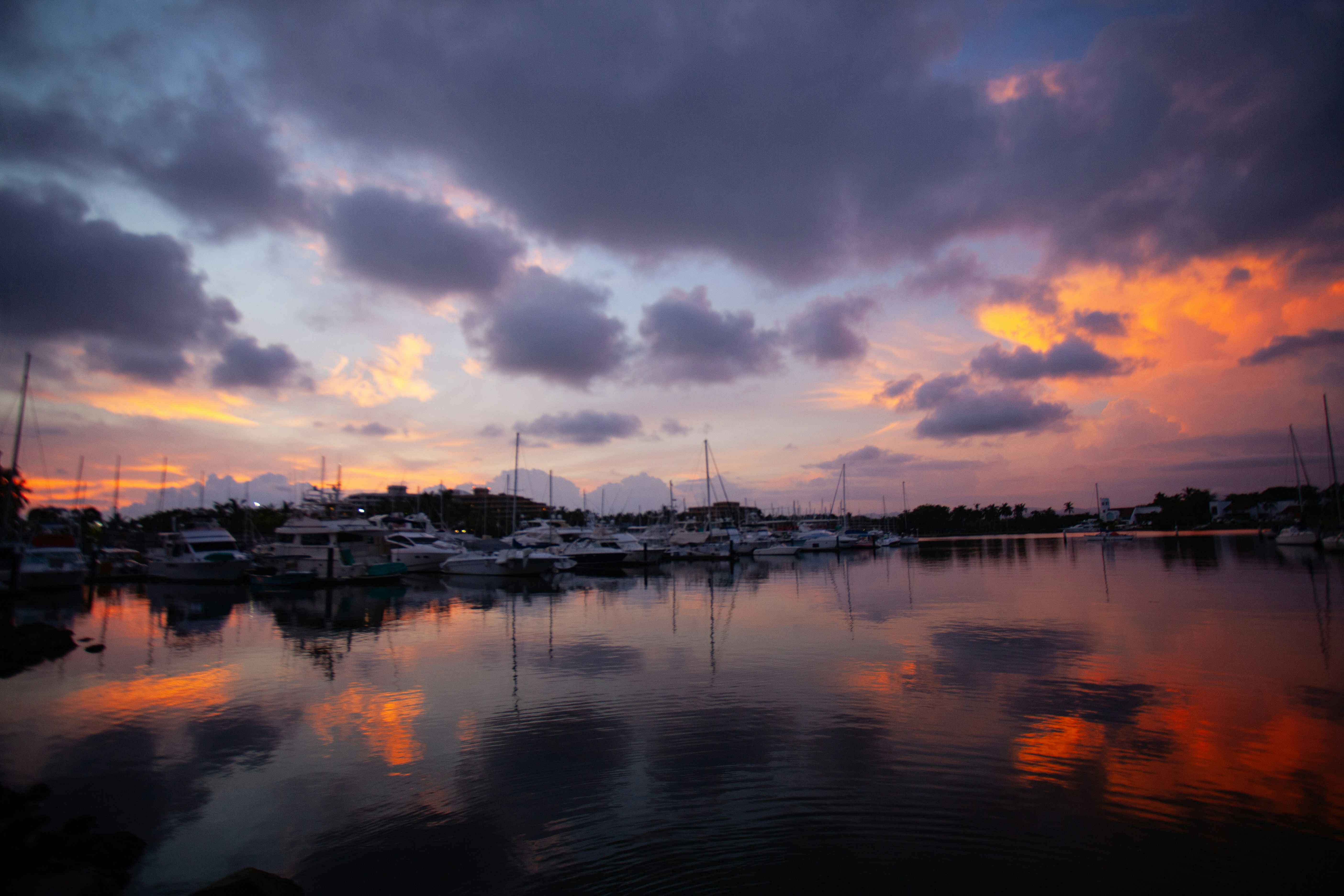 a harbor filled with lots of boats under a cloudy sky, 