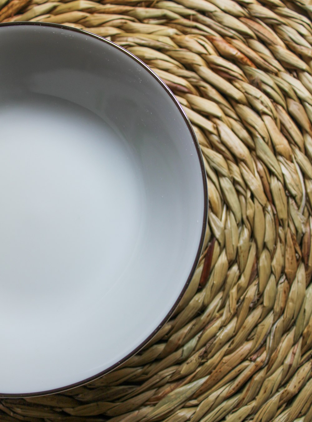 a white plate sitting on top of a woven place mat
