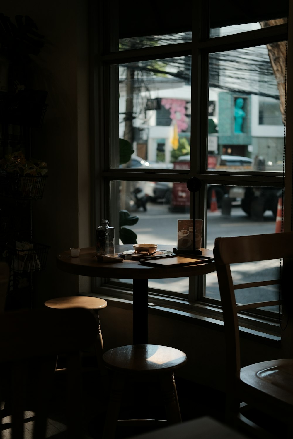 a table with a cup of coffee on it in front of a window