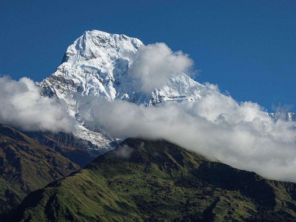 a large mountain covered in snow and clouds