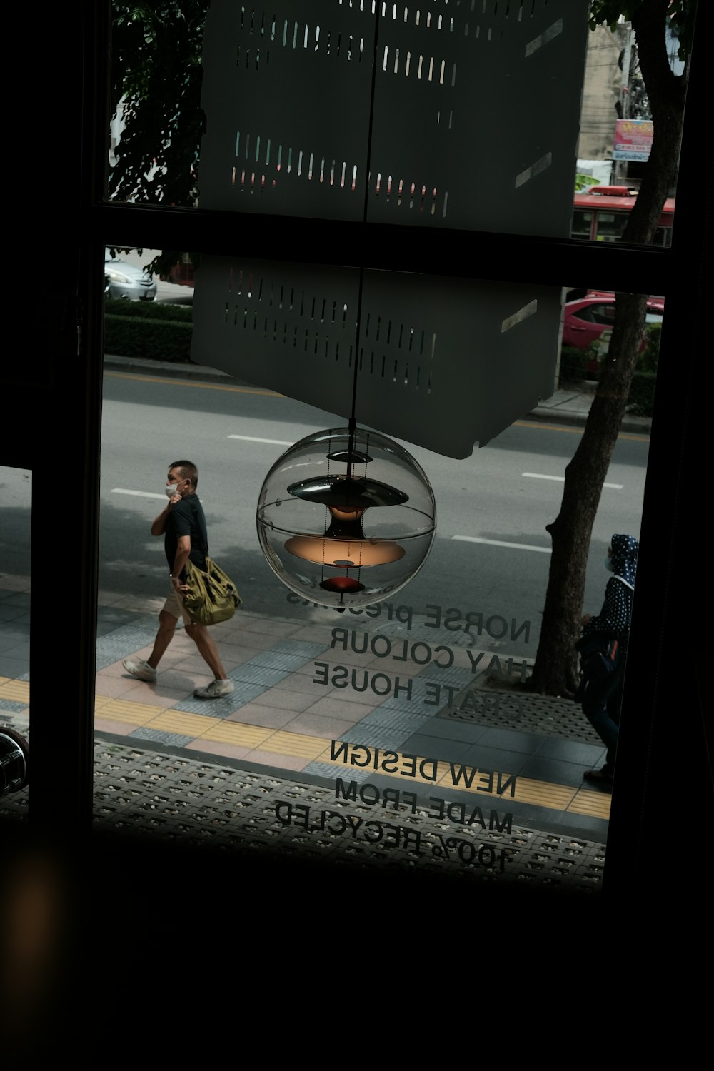 a woman walking down a street past a window