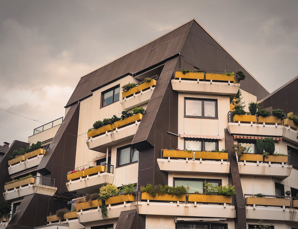 a very tall building with plants growing on the balconies