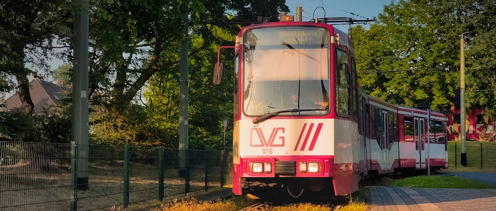 a red and white train traveling down train tracks