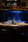 A sleek epoxy river table glowing under soft lighting in a cozy dining room.