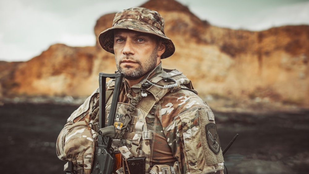 Un homme en tenue de camouflage tenant un fusil à la main