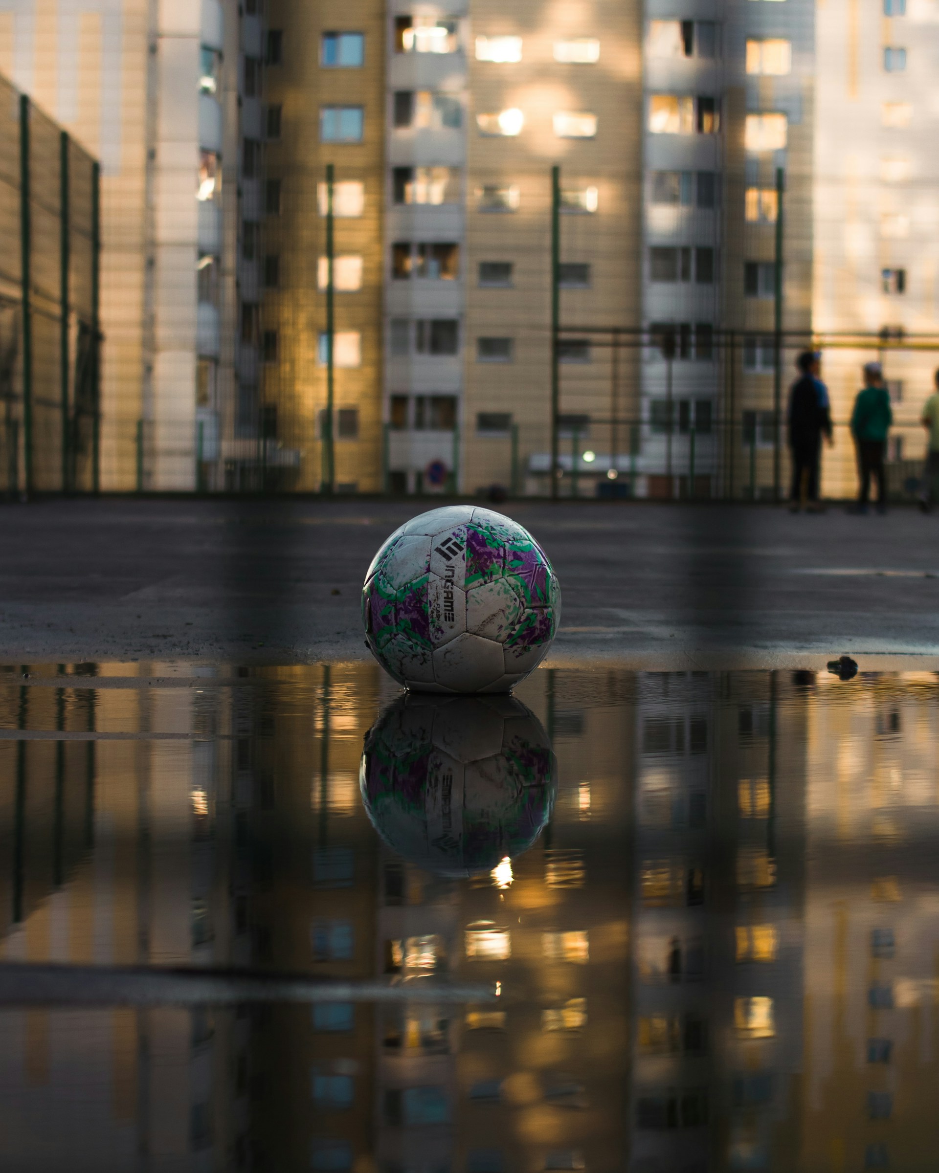 a soccer ball sitting on top of a wet ground