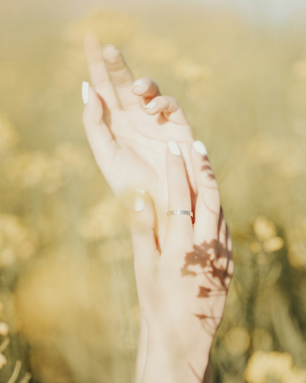 a woman holding her hand up in a field of flowers