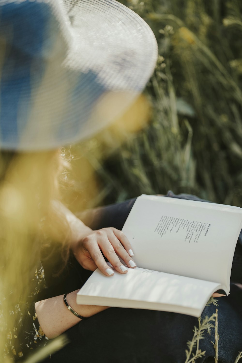 a person wearing a hat and reading a book