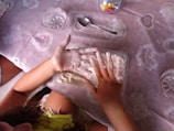 a little girl that is laying down on a table