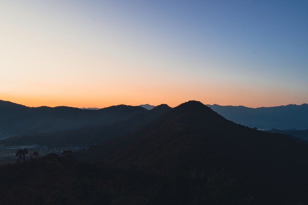 a view of a mountain with a sunset in the background