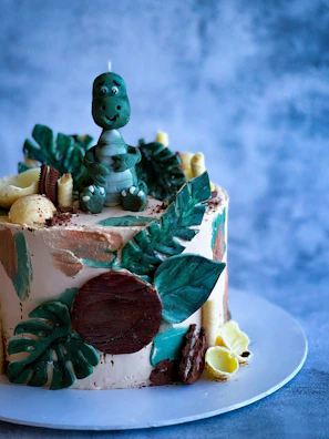 A colorful dinosaur-themed birthday cake surrounded by matching decorations.