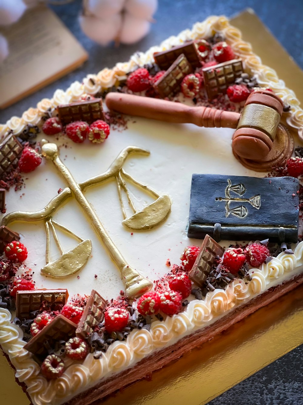 una torta decorata con una scala di giustizia e un libro di legge