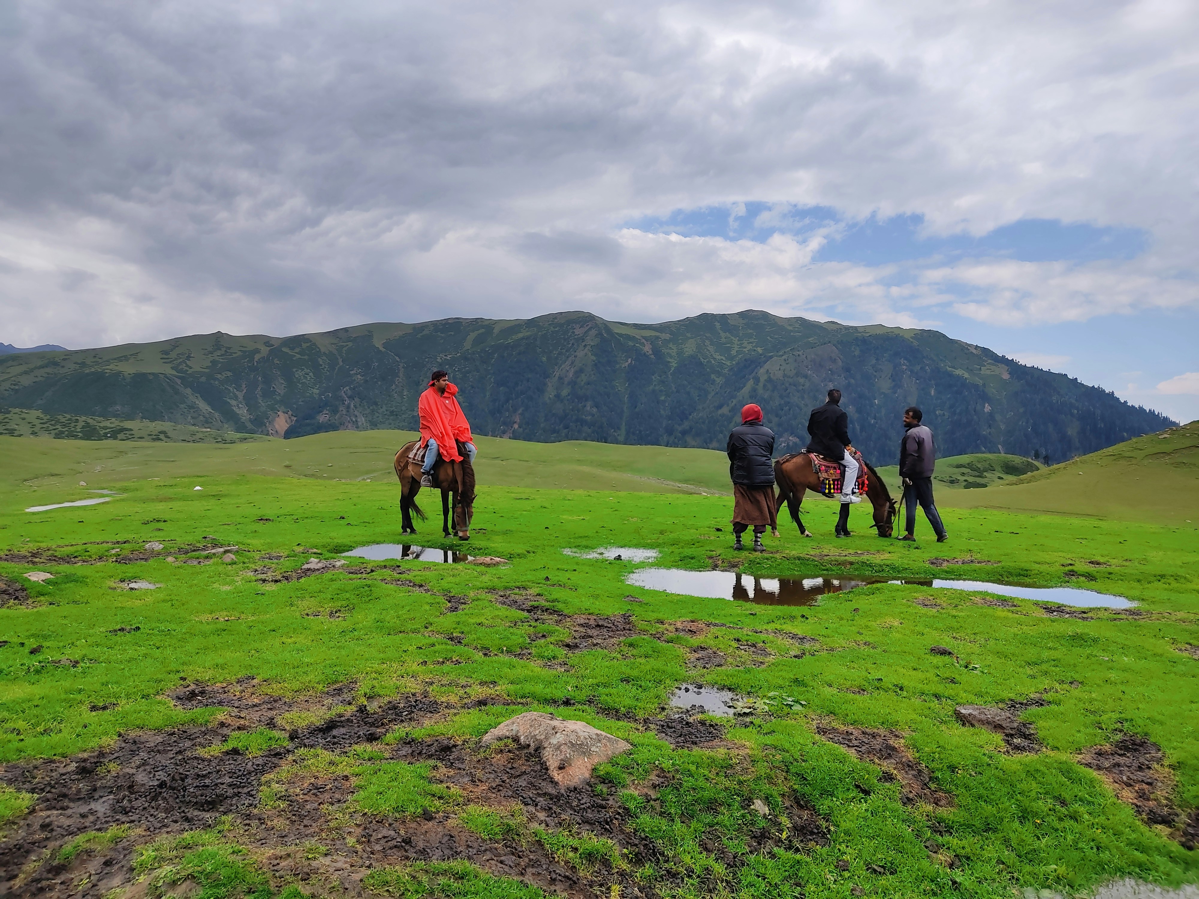 Pony ride through Pahalgam meadow with Himalayan peaks Kashmir India