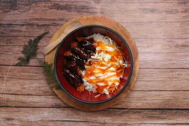 Grilled beef rice balls arranged on a rustic wooden board with sliced vegetables.