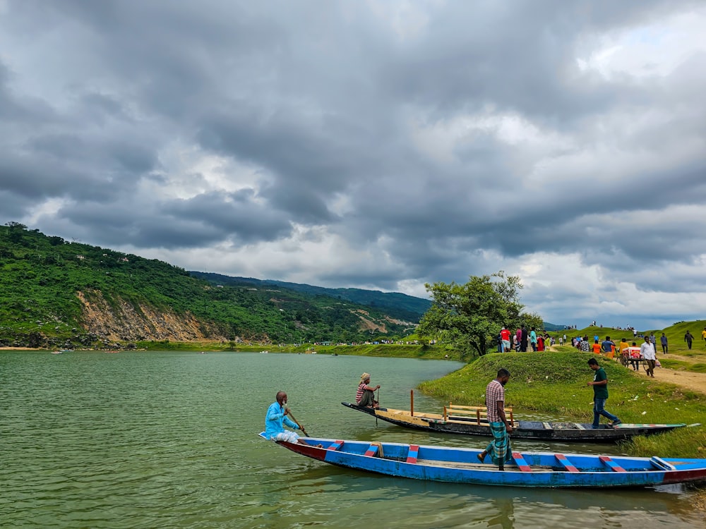 a group of people standing on top of a blue boat