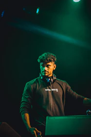 A candid backstage photo showing lor3nzo_music preparing for a set, headphones on, focused and ready.