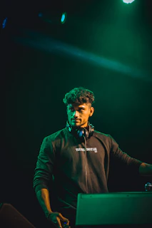 A candid backstage photo showing lor3nzo_music preparing for a set, headphones on, focused and ready.