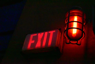 Close-up of a durable industrial emergency light mounted on a factory wall, glowing softly in dim surroundings.