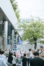 Bubble machine creating a stream of bubbles at a lively outdoor event.