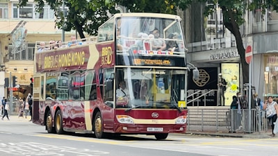 a red double decker bus driving down a street