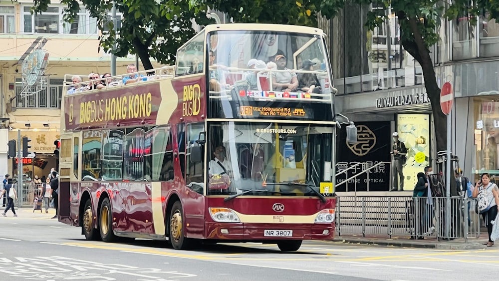 a red double decker bus driving down a street