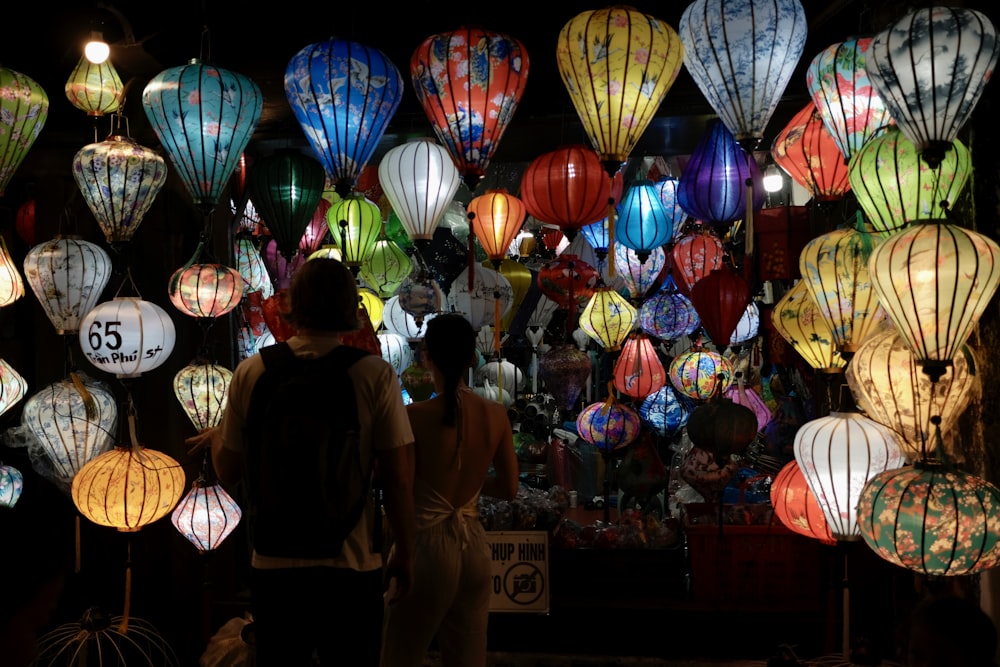 a group of people standing in front of a display of lanterns
