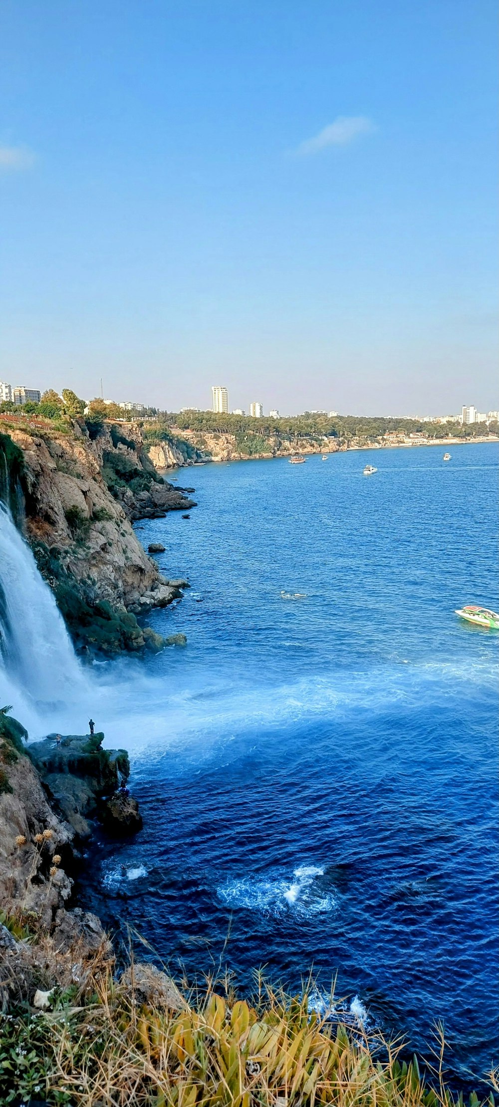 a large waterfall with a boat in the water