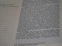 Close-up of hands holding an open Bible with notes and highlights.