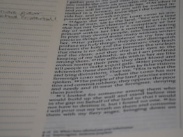 Close-up of open theological books and a notebook with handwritten notes.