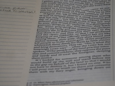 A close-up of hands holding a well-worn Bible with notes and highlights.