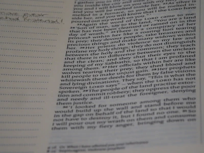 Close-up of hands holding an open Bible with notes and highlights.