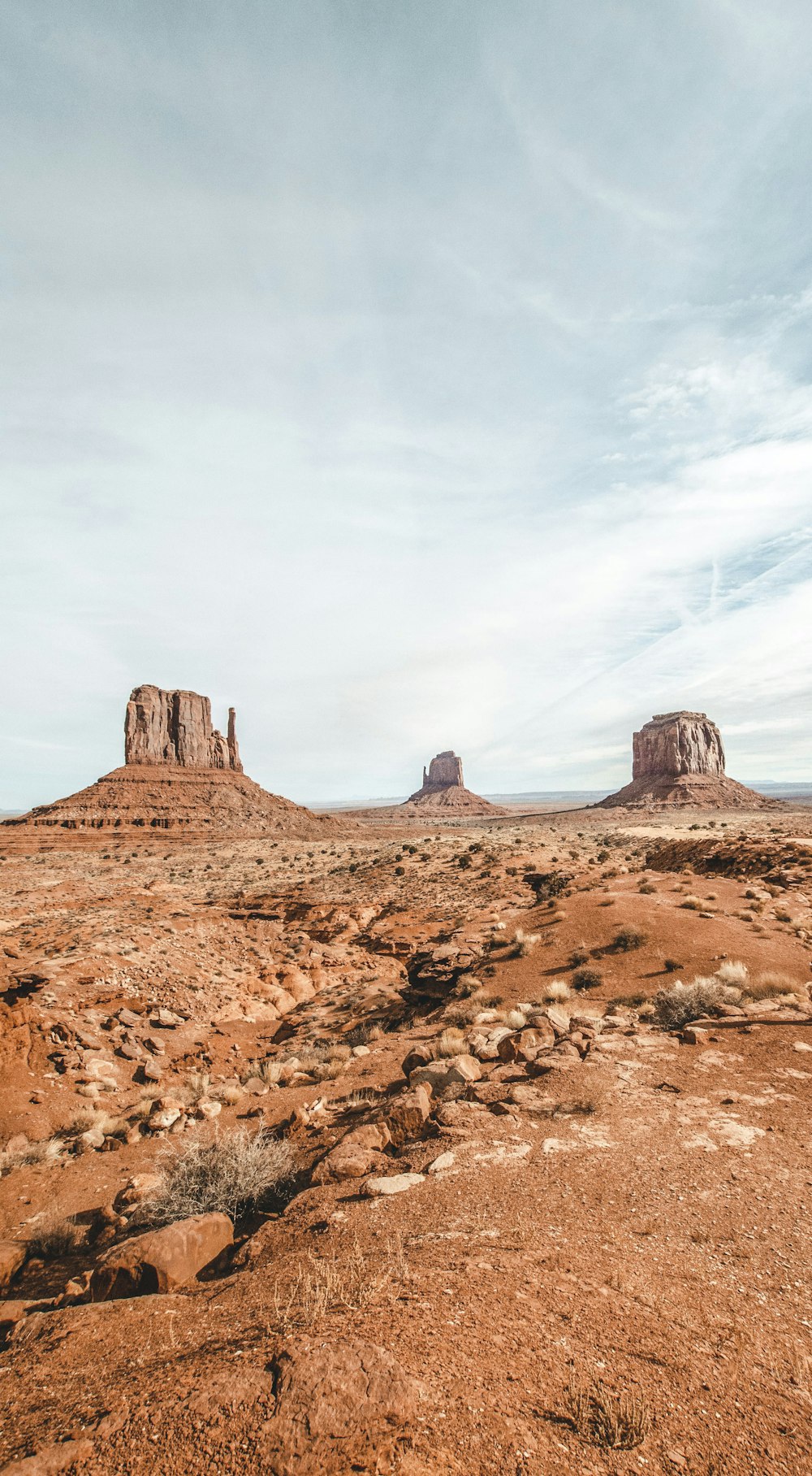 a dirt field with rocks in the distance